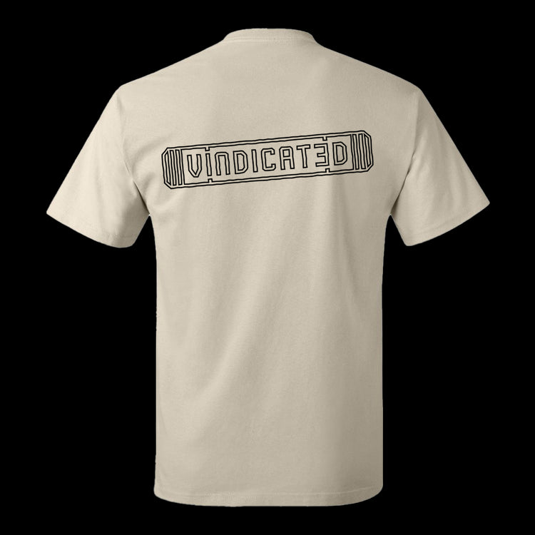 Backside of the off white Vindicated tee shirt with "Vindicated" in black across the middle of the back inside a skateboard