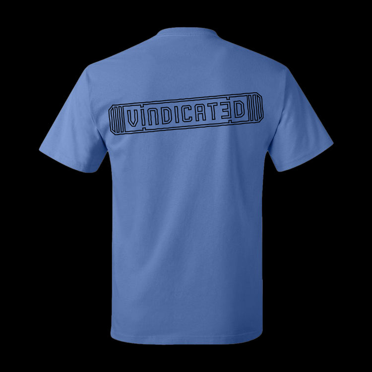 Backside of the Carolina Blue Vindicated tee shirt with "Vindicated" in black across the middle of the back inside a skateboard