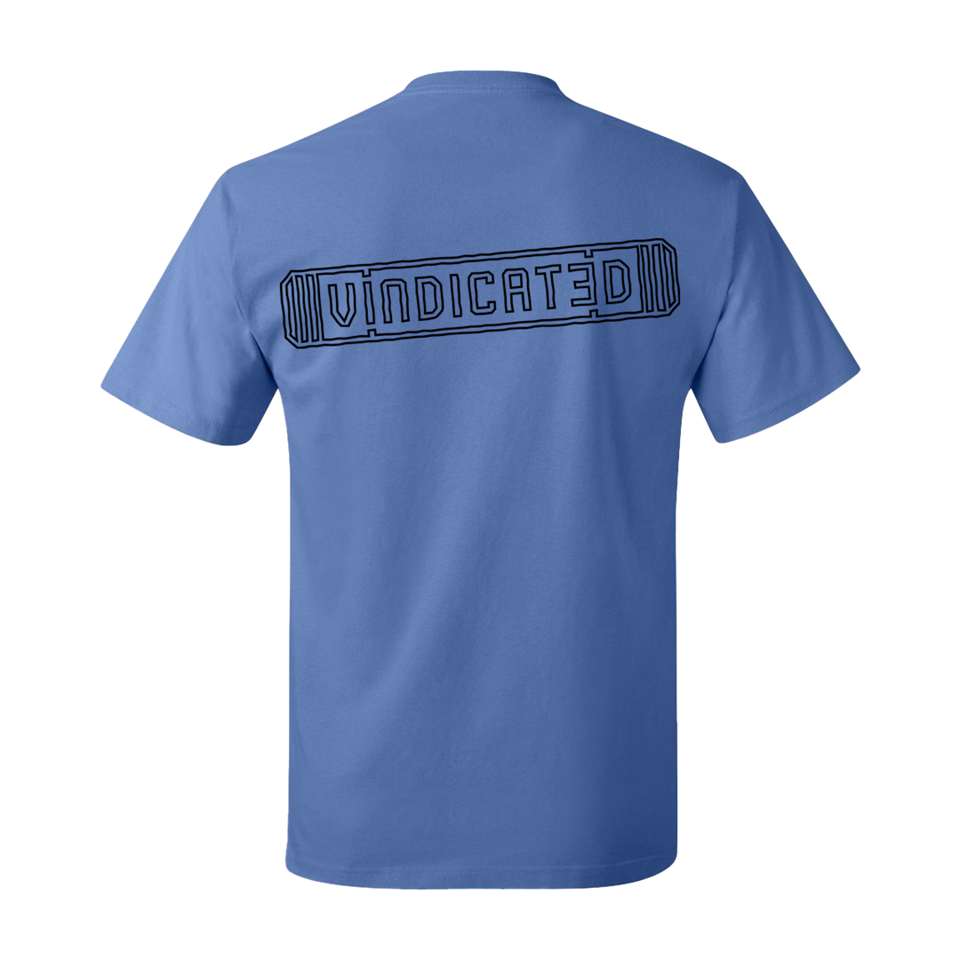 Backside of the Carolina Blue Vindicated tee shirt with "Vindicated" in black across the middle of the back inside a skateboard